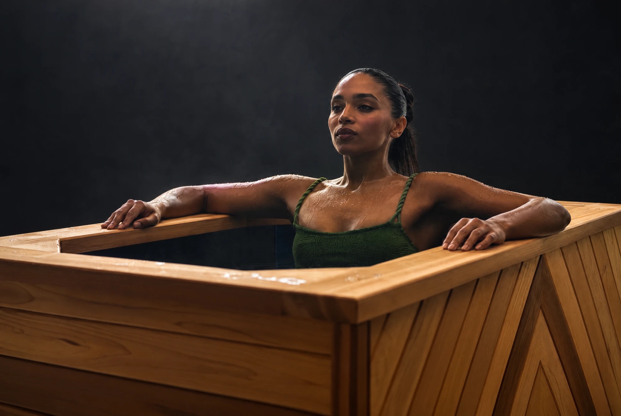 A person in a Brass Monkey cedar ice bath, calm and composed after cold water immersion